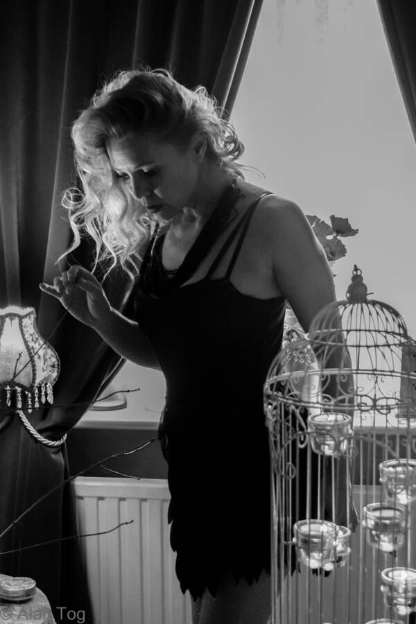 photographer Alan Tog fashion modelling photo. a beautifully experienced model doing her best to portray a 1920s theme in a modernish building based on a flapper girl of the period the short cocktail black dress has a fringe around it that we tried to capture 