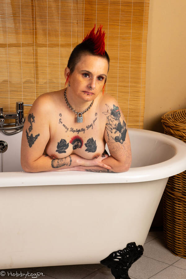 photographer Alan Tog topless modelling photo. punk styled model posing in the bath with boobs resting on the edge of the bath.