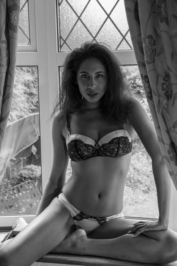 photographer Alan Tog lingerie modelling photo. beautiful young black professional model posing in lingerie sat in the window.